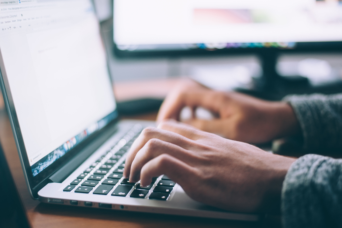 Image of a person typing into a computer