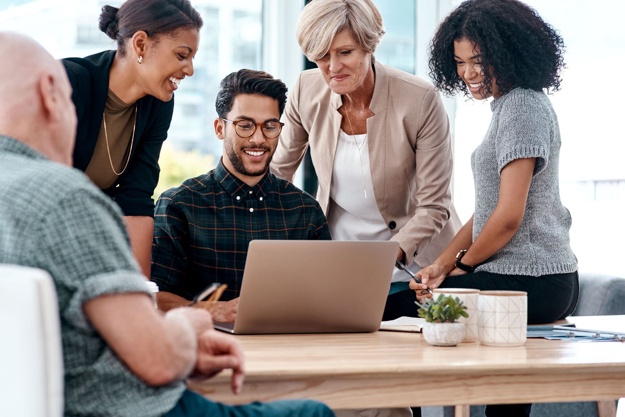 Shot of a group of businesspeople working together on a laptop in an office